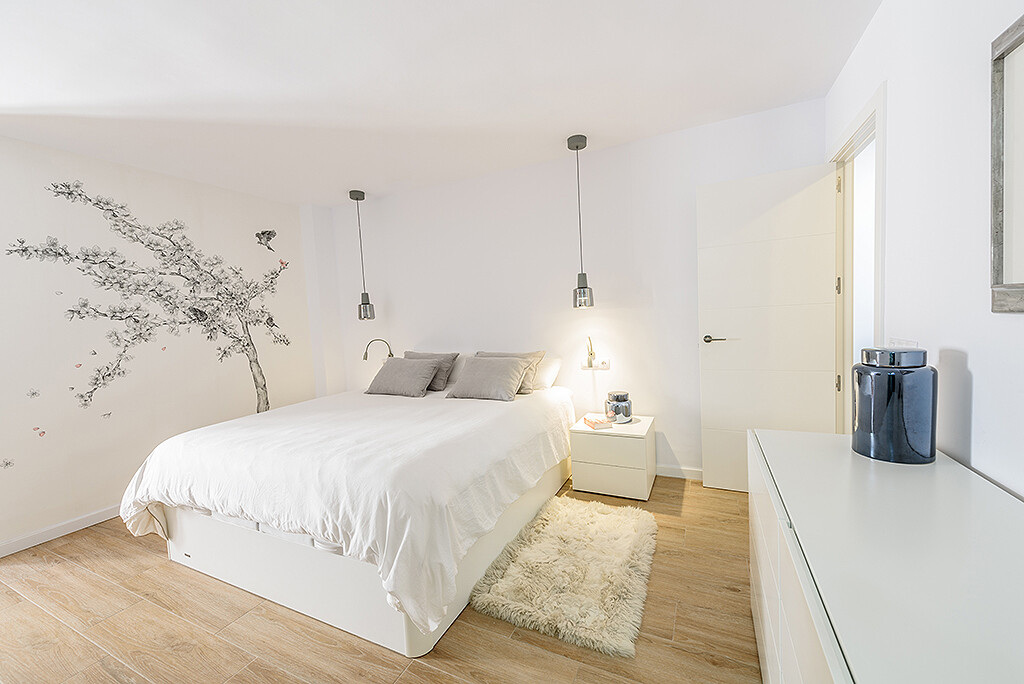 Dormitorio moderno en tonos blancos con almacenamiento bajo la cama y decoración minimalista, pensado por Virginia Perez para maximizar el espacio y crear un ambiente sereno en una casa pequeña