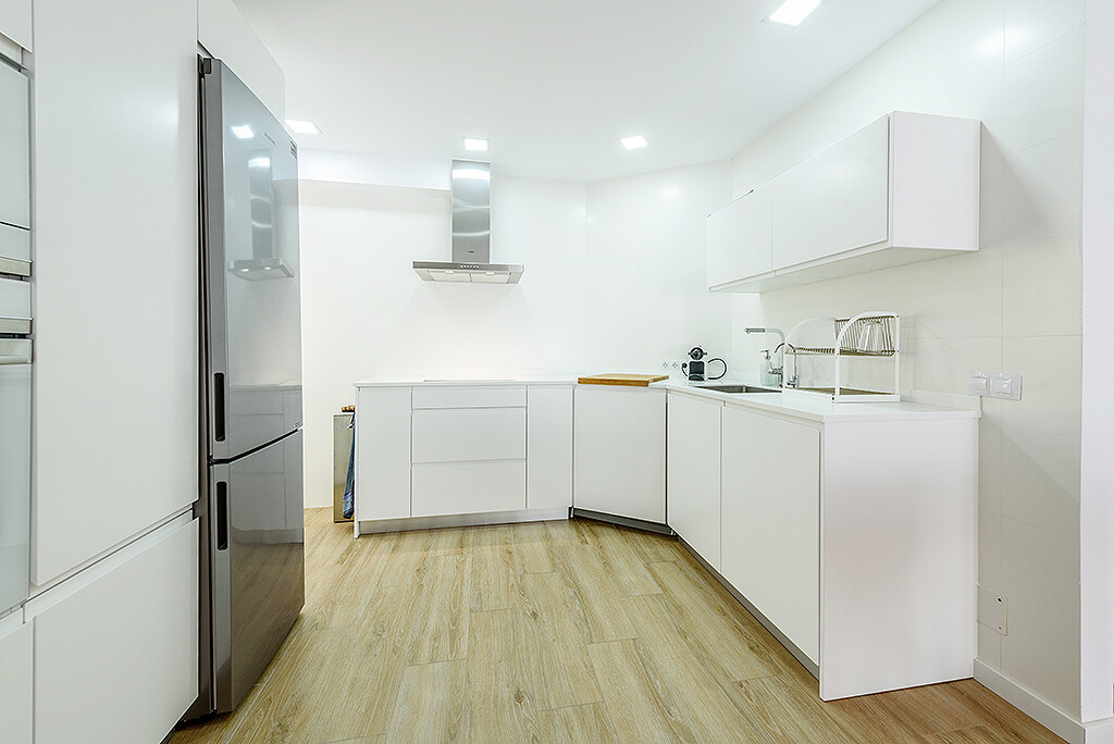 Cocina blanca moderna y funcional con muebles integrados, optimizando cada espacio pequeño con un diseño limpio y minimalista. Un ejemplo de cómo maximizar espacios pequeños, por Virginia Perez, interiorista de Mallorca