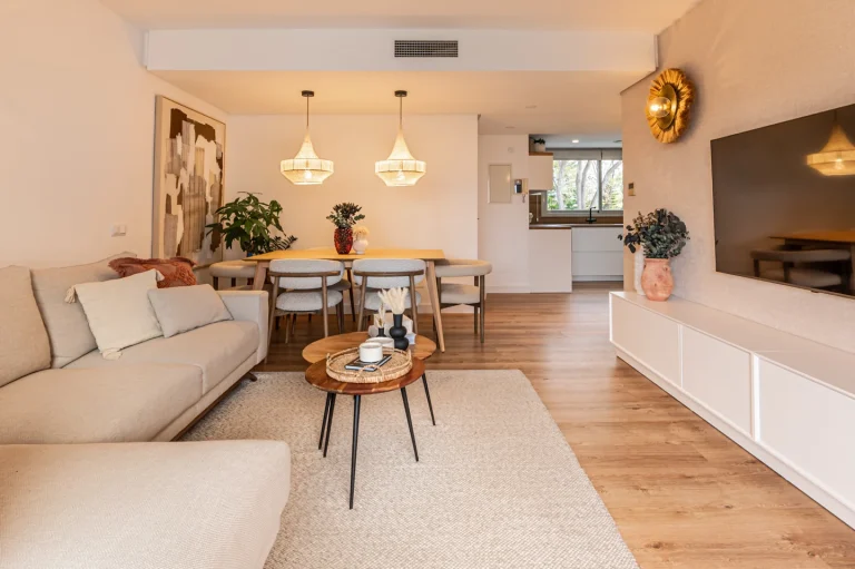 Dividir espacios con muebles sin perder luz, amplitud ni estilo 2 Imagen de un hogar diseñado por Virginia Perez, en la que se ve el uso de una alfombra para delimitar el ambiente del sofá y TV.